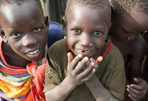 two-children-standing-close-together-and-smiling-toward-the-camera