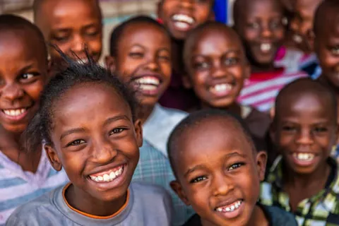 a-group-of-children-smiling-together,-with-two-children-in-the-foreground