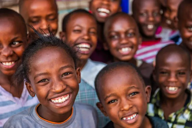 A group of children smiling together, with two children in the foreground. a-group-of-children-smiling-together,-with-two-children-in-the-foreground-for-owaid-orphan-and-widow-support