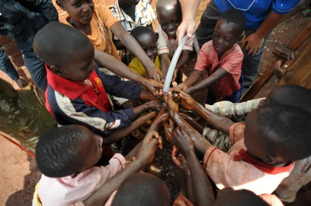 Children standing in a circle with their hands joined in the center. children-standing-in-a-circle-with-their-hands-joined-in-the-center-for-owaid-orphan-and-widow-support