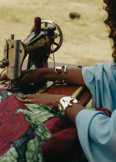 hands-guiding-patterned-fabric-through-a-sewing-machine